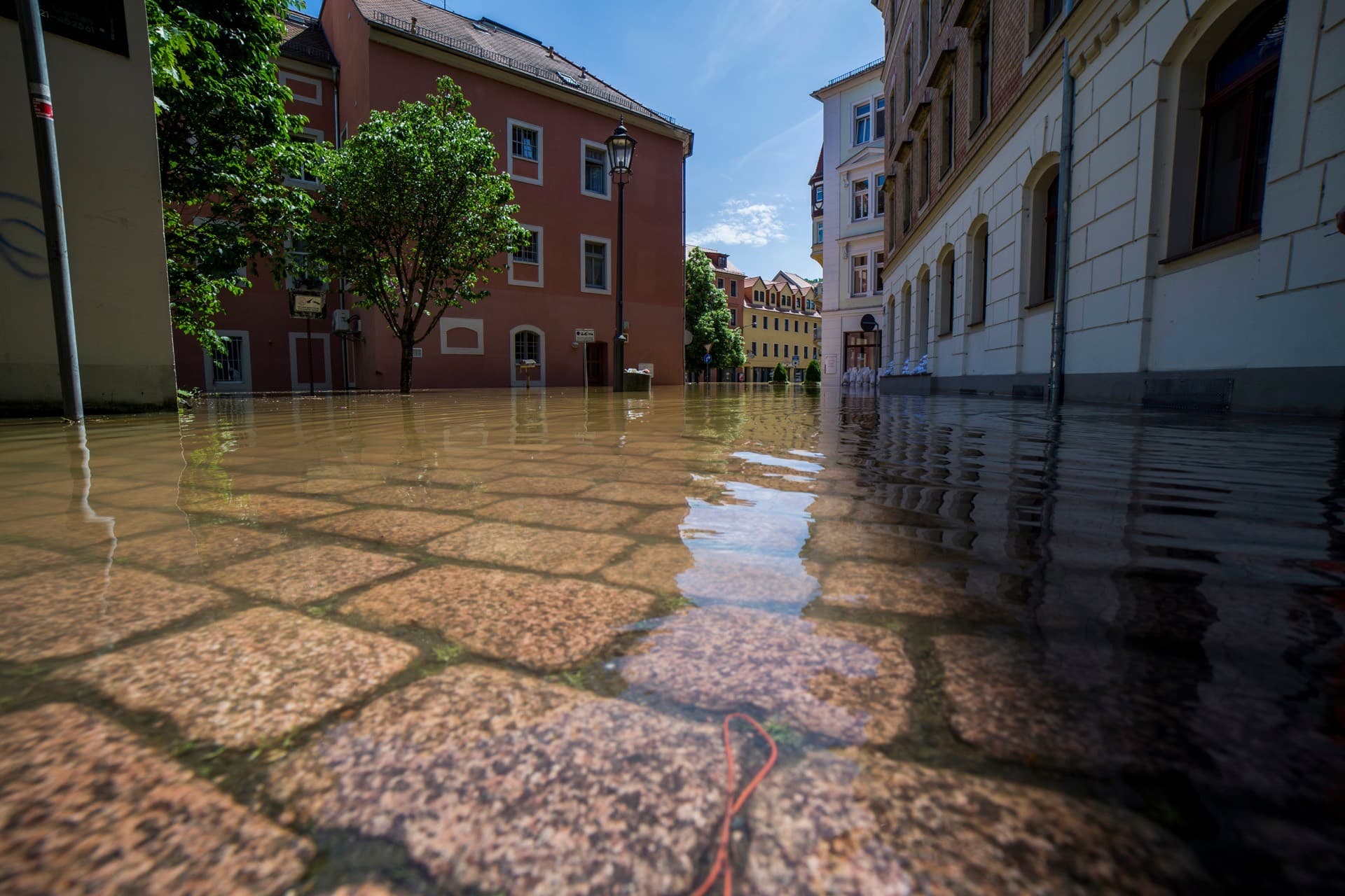 Überflutete Wohnstraße zwischen Altbauten nach Hochwasser