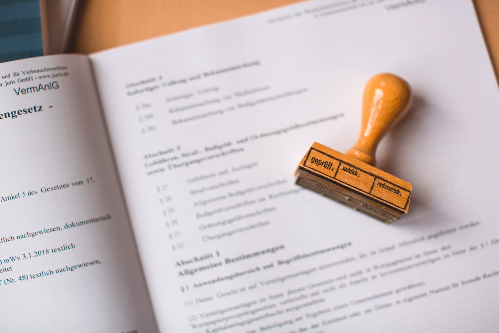 Prüfstempel liegt auf einem aufgeschlagenen Gesetzestext