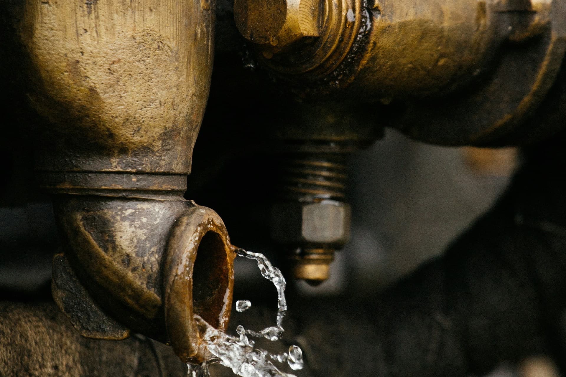 Wasser tritt aus einem Messingrohr aus