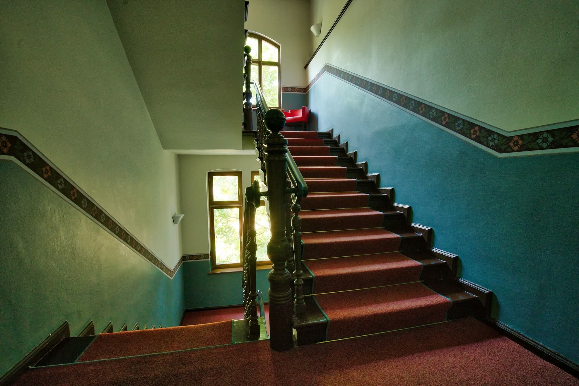 Treppenhaus eines Altbau-Wohnhauses mit rotem Läufer