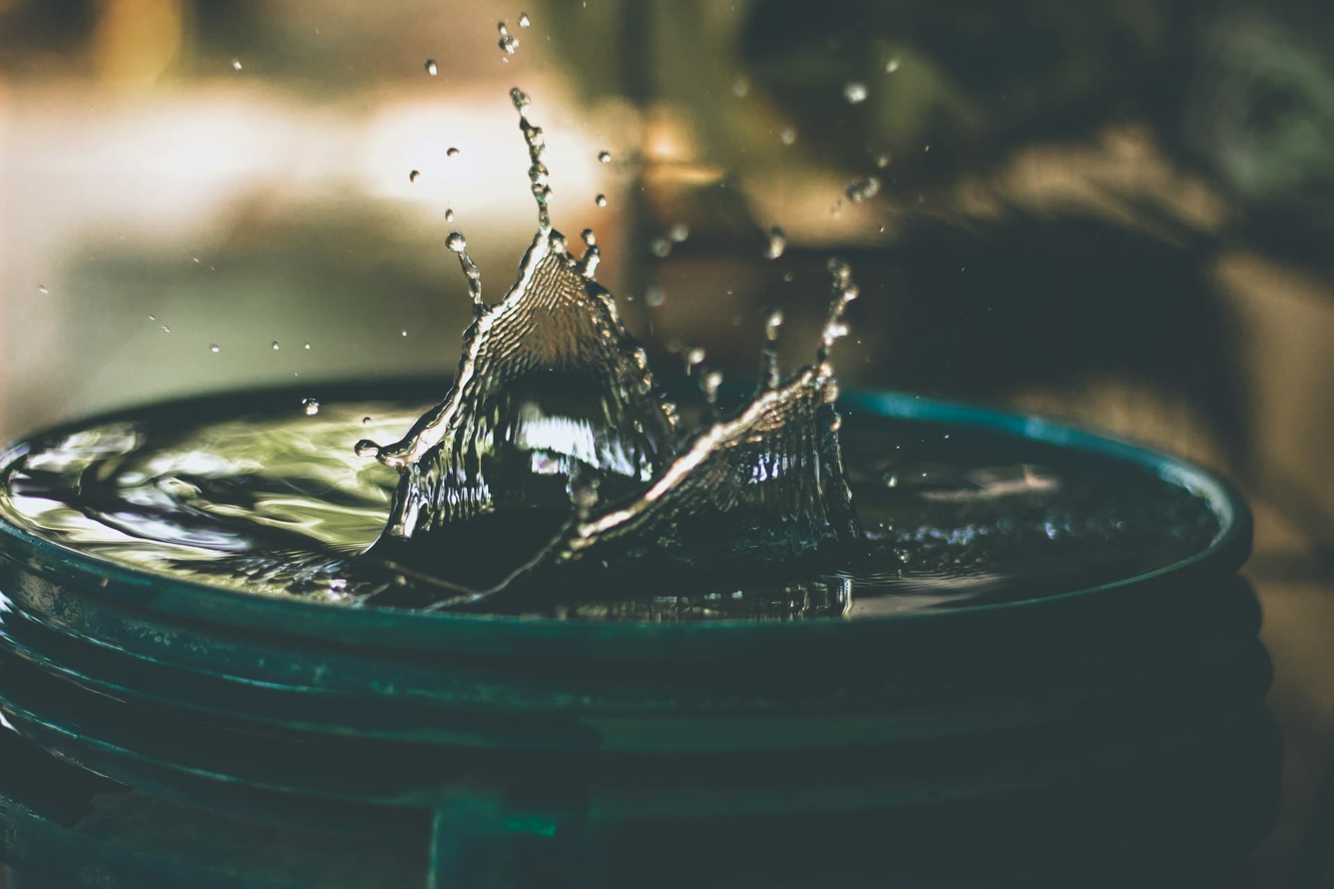 Wasser spritzt in einen gefüllten Eimer